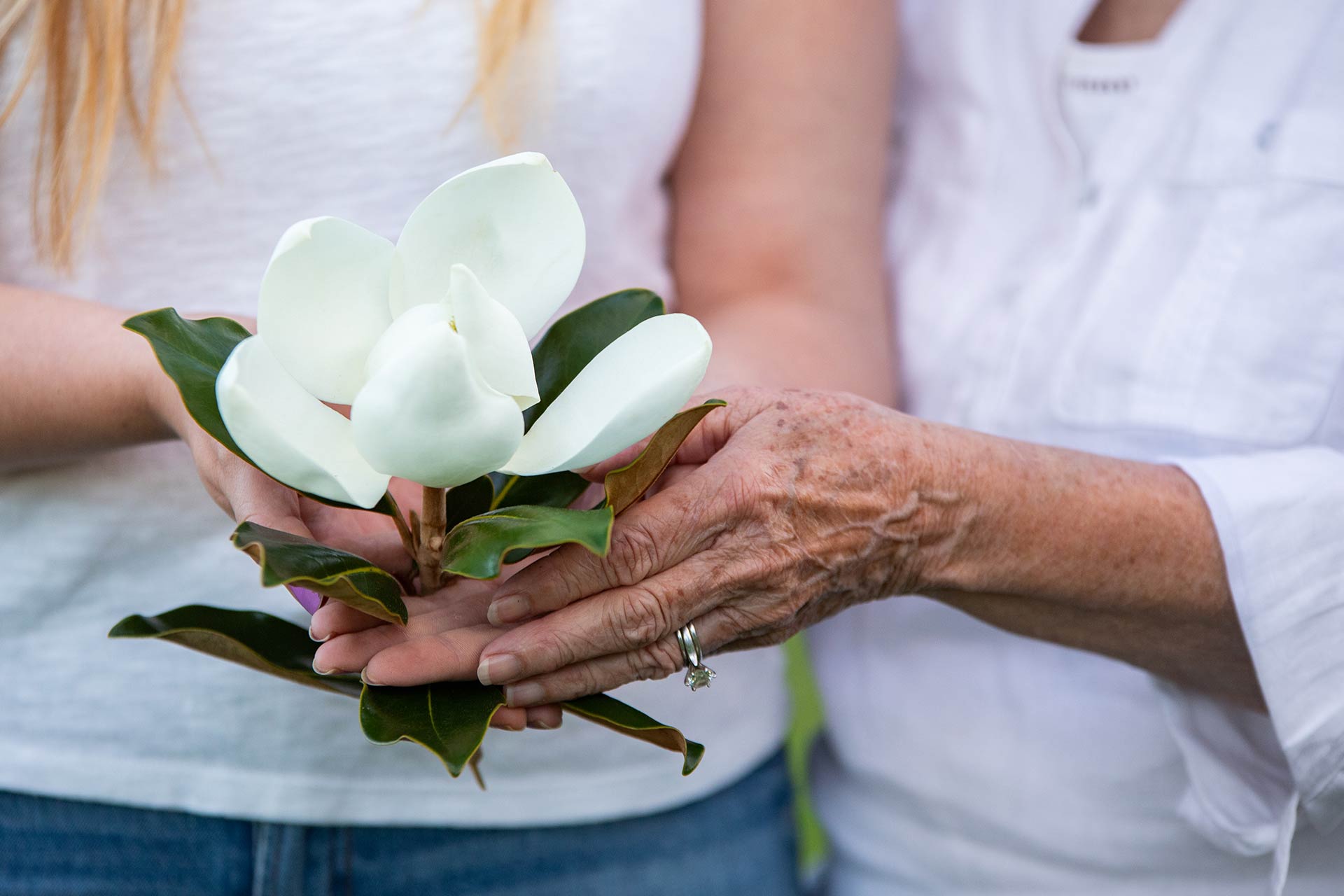 Two Women Holding Magnolia Blossom